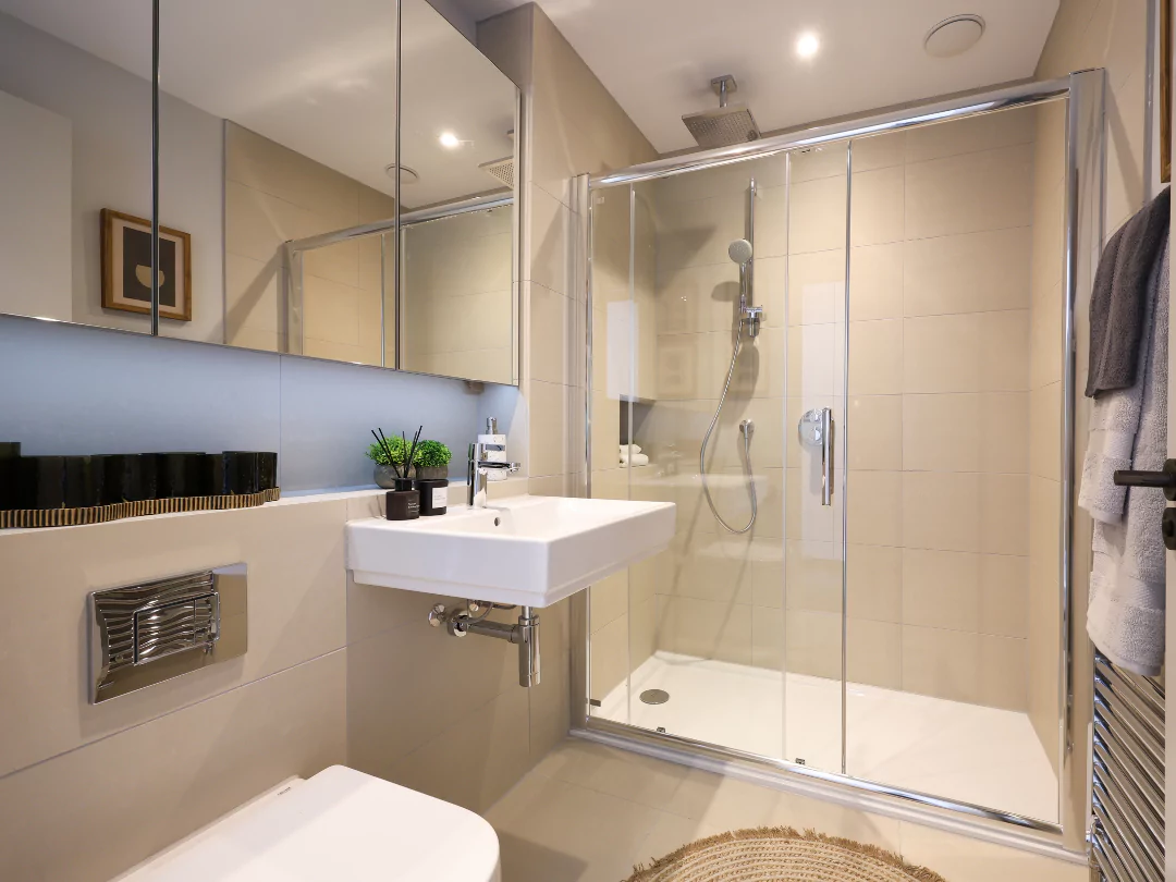 Stylish shower room with dark style details and fluffy grey towels perfectly placed on the towel warmer.