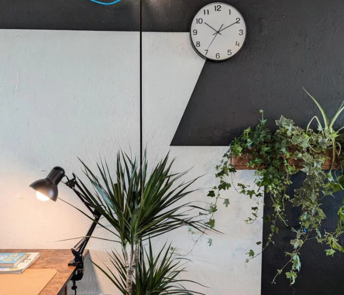 A lit workstation within Boxworks' flexible small office space with black and white accents and green plants.