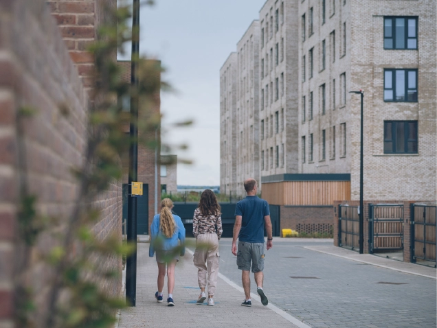 Three people walking through the neighbourhood at Brabazon, Bristol. 