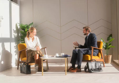 Young professionals dressed in business clothing smiling and talking in an office building at Brabazon, Bristol.