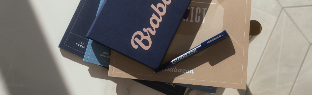 A neatly stacked set of books with a dark blue cover showing the word "Brabazon" in cursive.