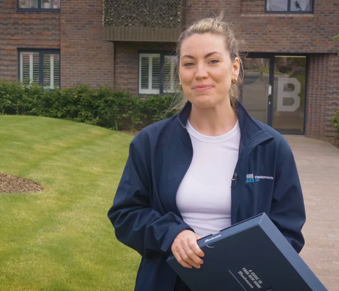 Young female standing outside holding a blue folder